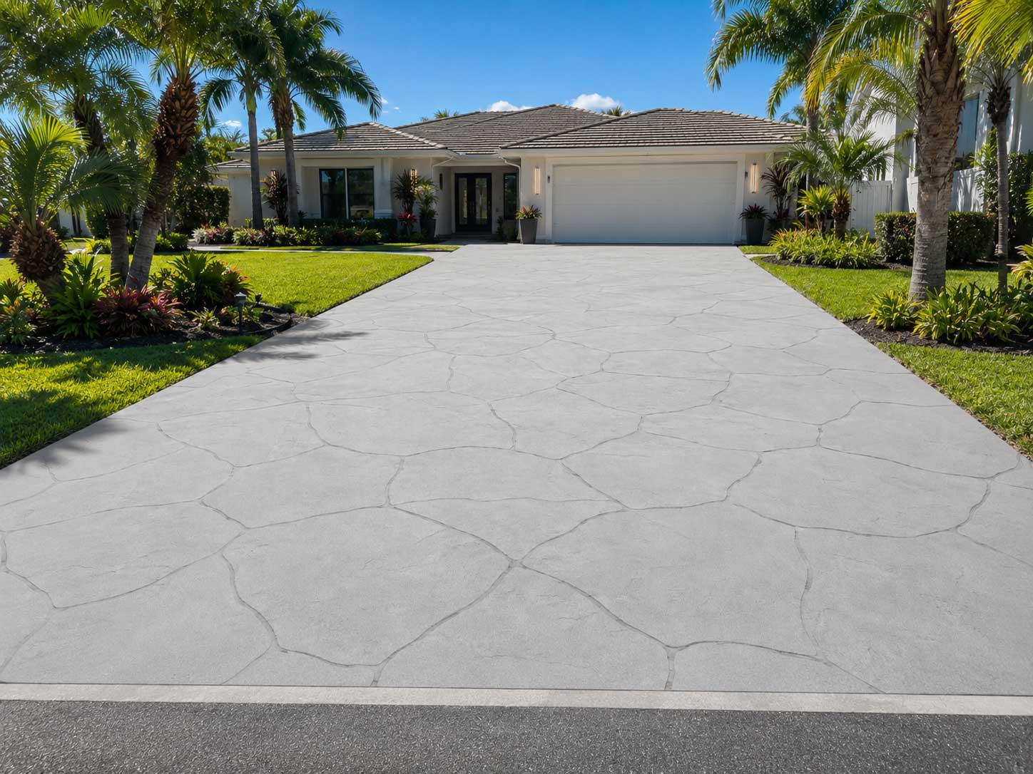 Light gray stamped concrete driveway with a large flagstone pattern