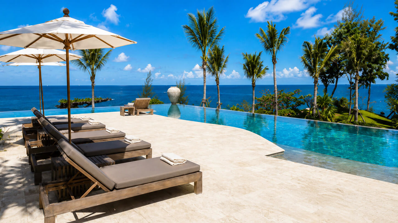 Renovated travertine paver pool deck around an infinity edge pool with an ocean view, completed at a Boynton Beach residence