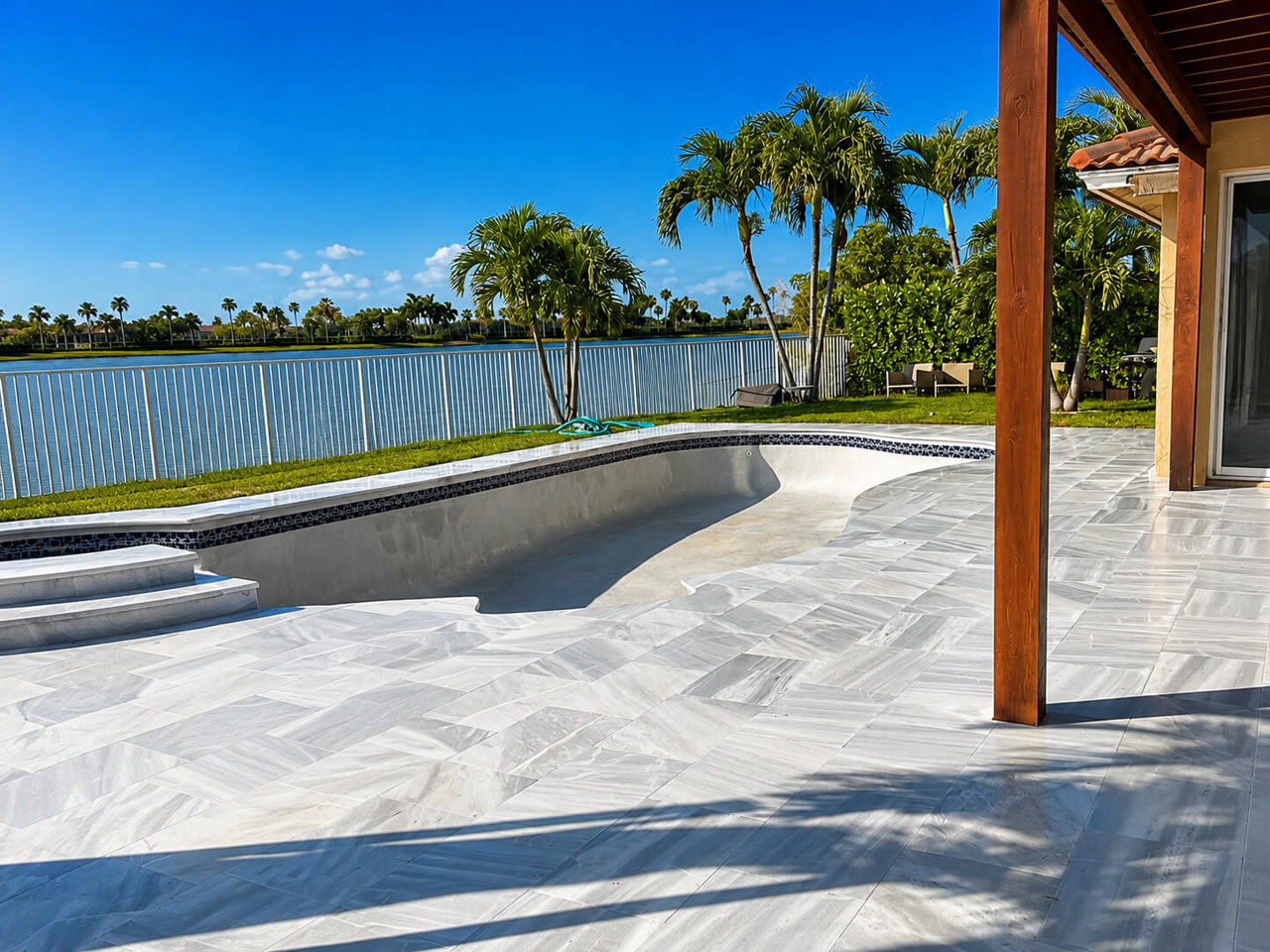 Pool under construction with the new white marble paver deck already installed for a Coral Springs homeowner