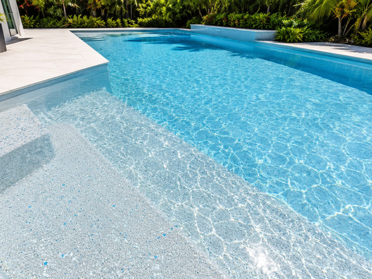 Light pebble finish visible under clear water across wide entry steps and a sun shelf at a West Lake pool